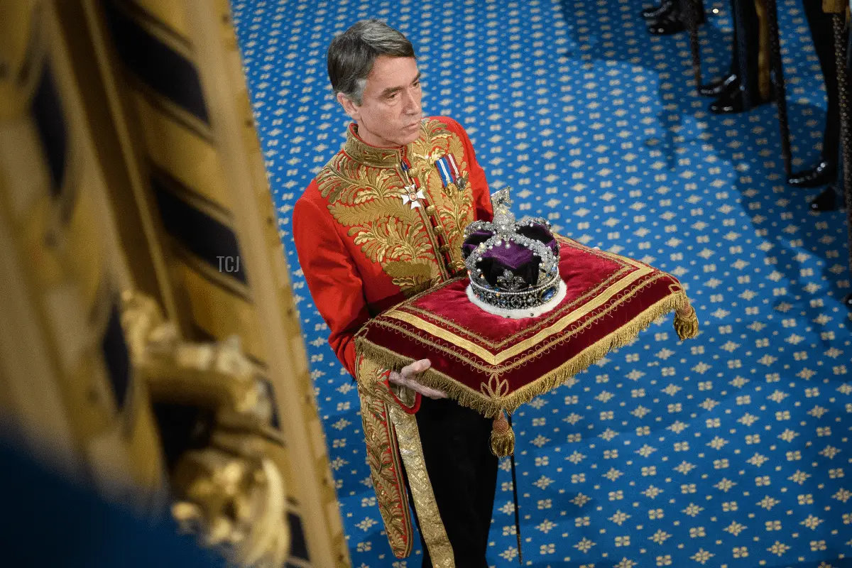 I Marchesi di Cholmondeley, in uniforme cerimoniale, tengono la corona della Regina all'esterno della Camera dei Lords dopo il discorso della Regina durante l'apertura ufficiale del Parlamento al Palazzo di Westminster il 14 ottobre 2019 a Londra