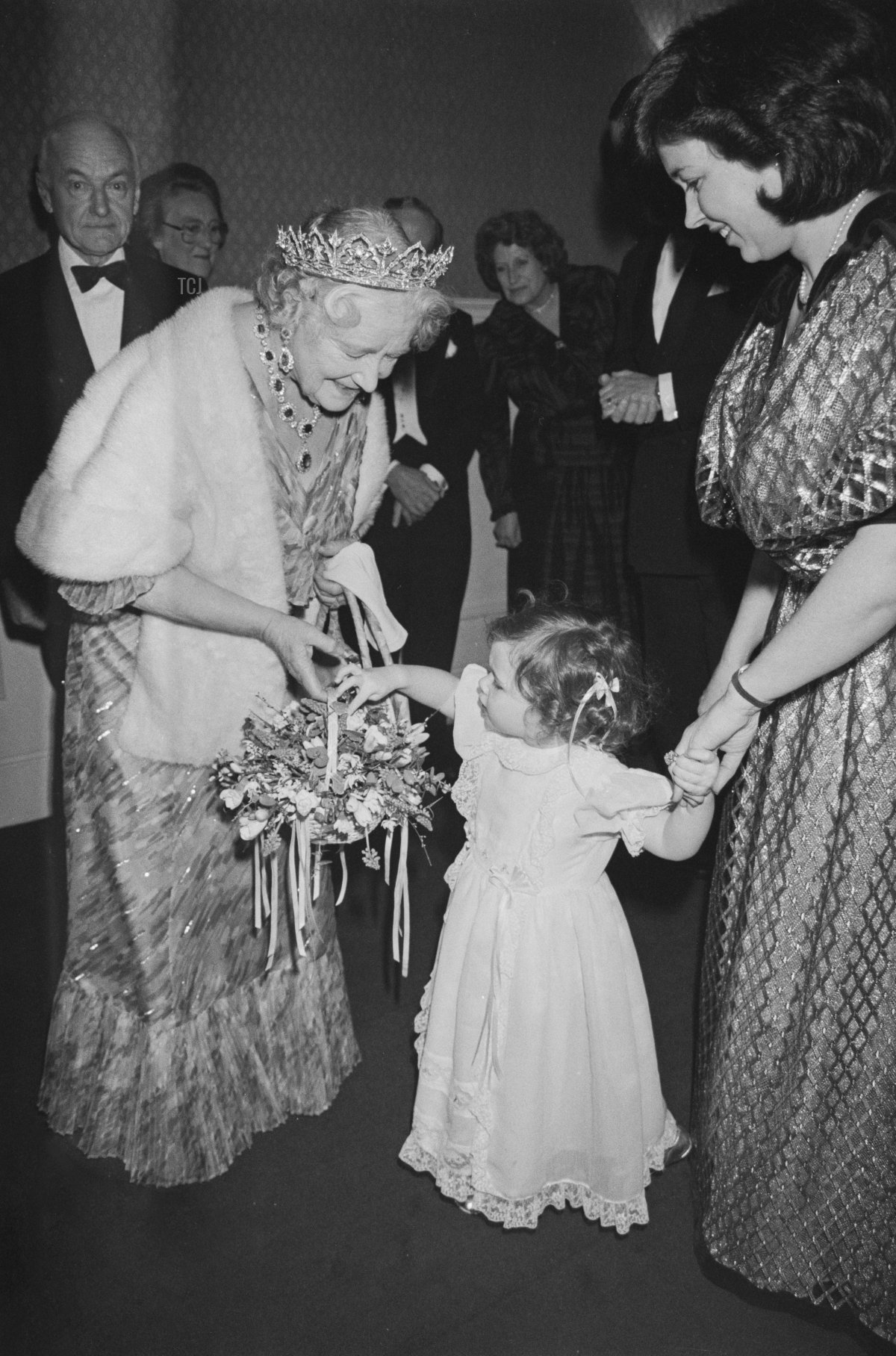 La regina Elisabetta La Regina Madre è accolta da una giovane ragazza che le porge un cesto di fiori alla premiere del film 'Un Passaggio in India', all'Odeon di Leicester Square a Londra, Inghilterra, 1 marzo 1985