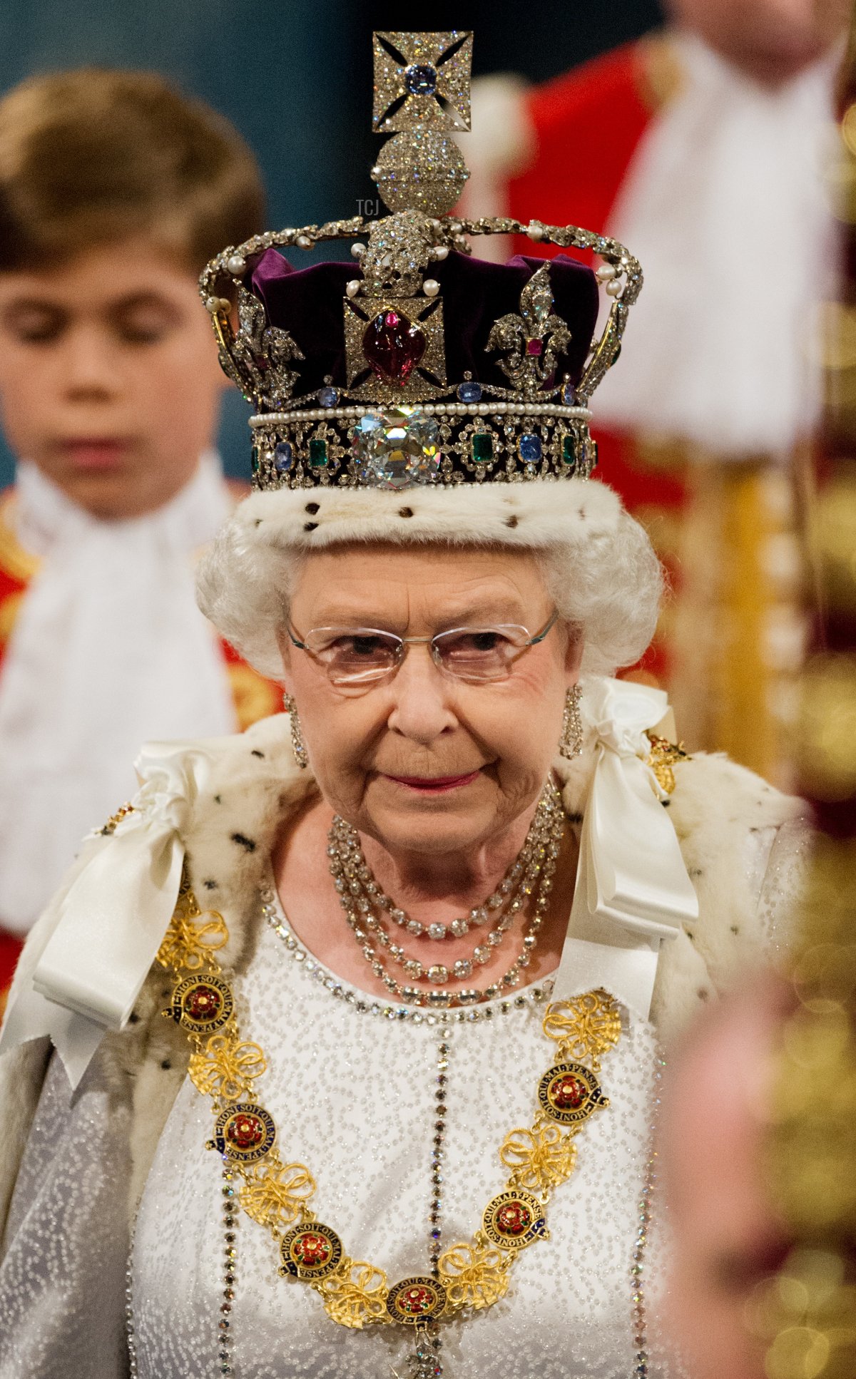 La regina Elisabetta II d'Inghilterra indossa la Corona Imperiale mentre attraversa la Galleria Reale verso la Camera dei Lords nel Palazzo di Westminster durante l'apertura dello stato del Parlamento a Londra il 9 maggio 2012