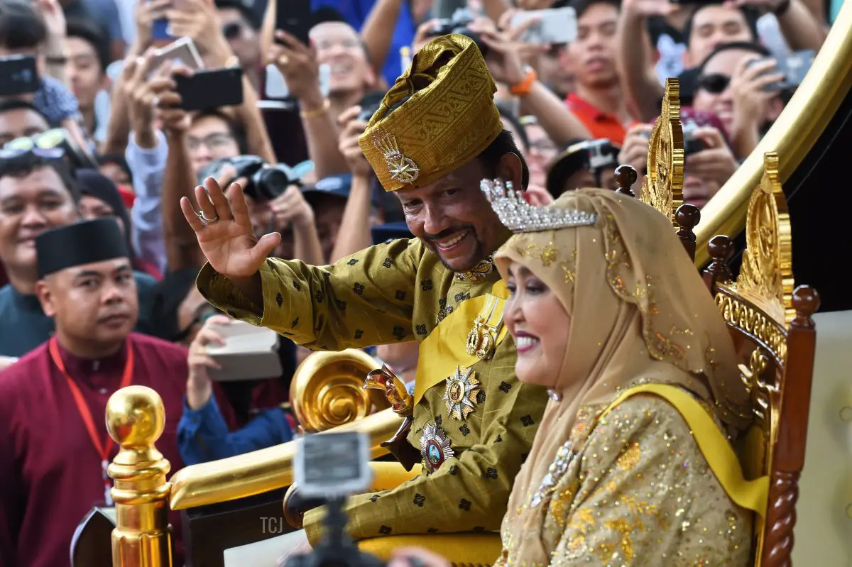 Il sultano del Brunei Hassanal Bolkiah (centro-S) e la regina Saleha (centro-D) salutano dal carro reale durante una processione per celebrare il suo giubileo d'oro di ascesa al trono a Bandar Seri Begawan il 5 ottobre 2017