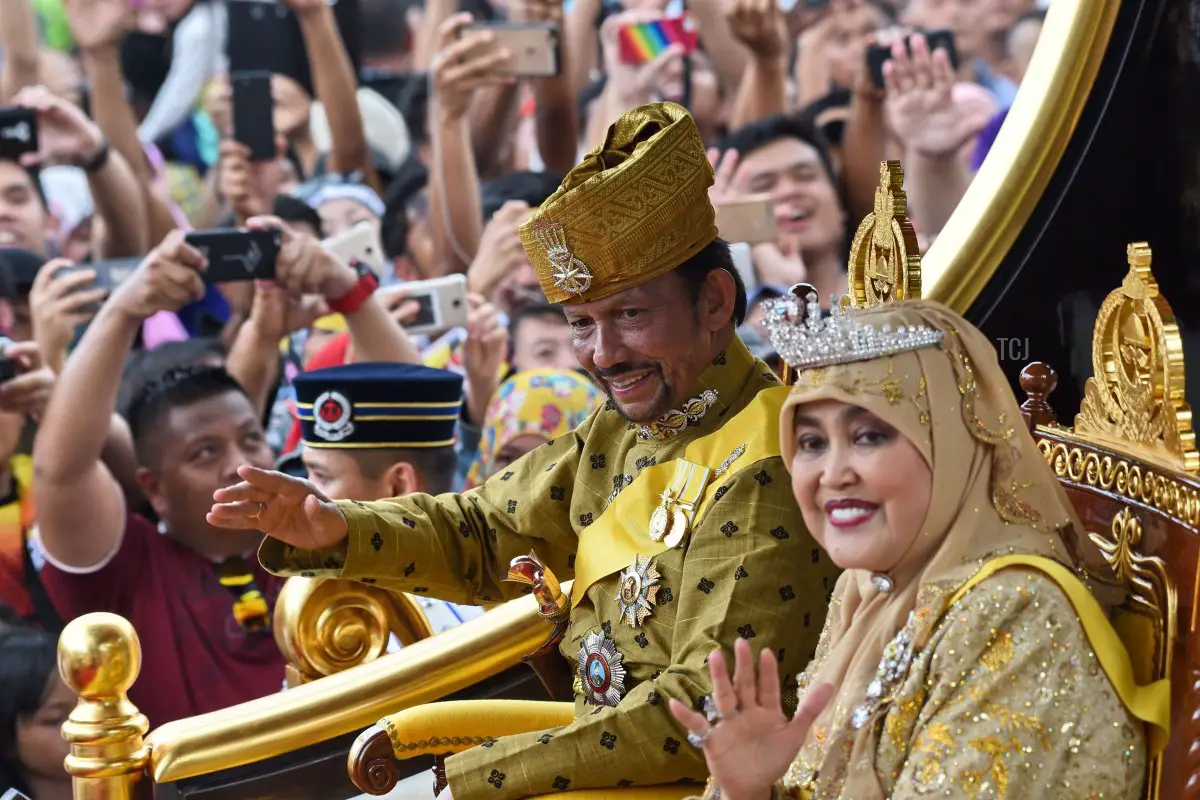 Il sultano del Brunei Hassanal Bolkiah (centro-S) e la regina Saleha (centro-D) salutano dal carro reale durante una processione per celebrare il suo giubileo d'oro di ascesa al trono a Bandar Seri Begawan il 5 ottobre 2017