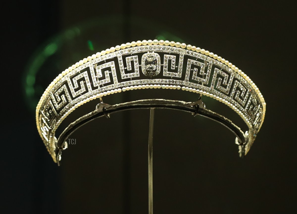 Un dipendente del museo posa accanto a una tiara Cartier di diamanti e perle salvata dal Lusitania presentata in una nuova mostra 'Ocean Liners: Speed and Style' al Victoria and Albert Museum di Londra il 31 gennaio 2018