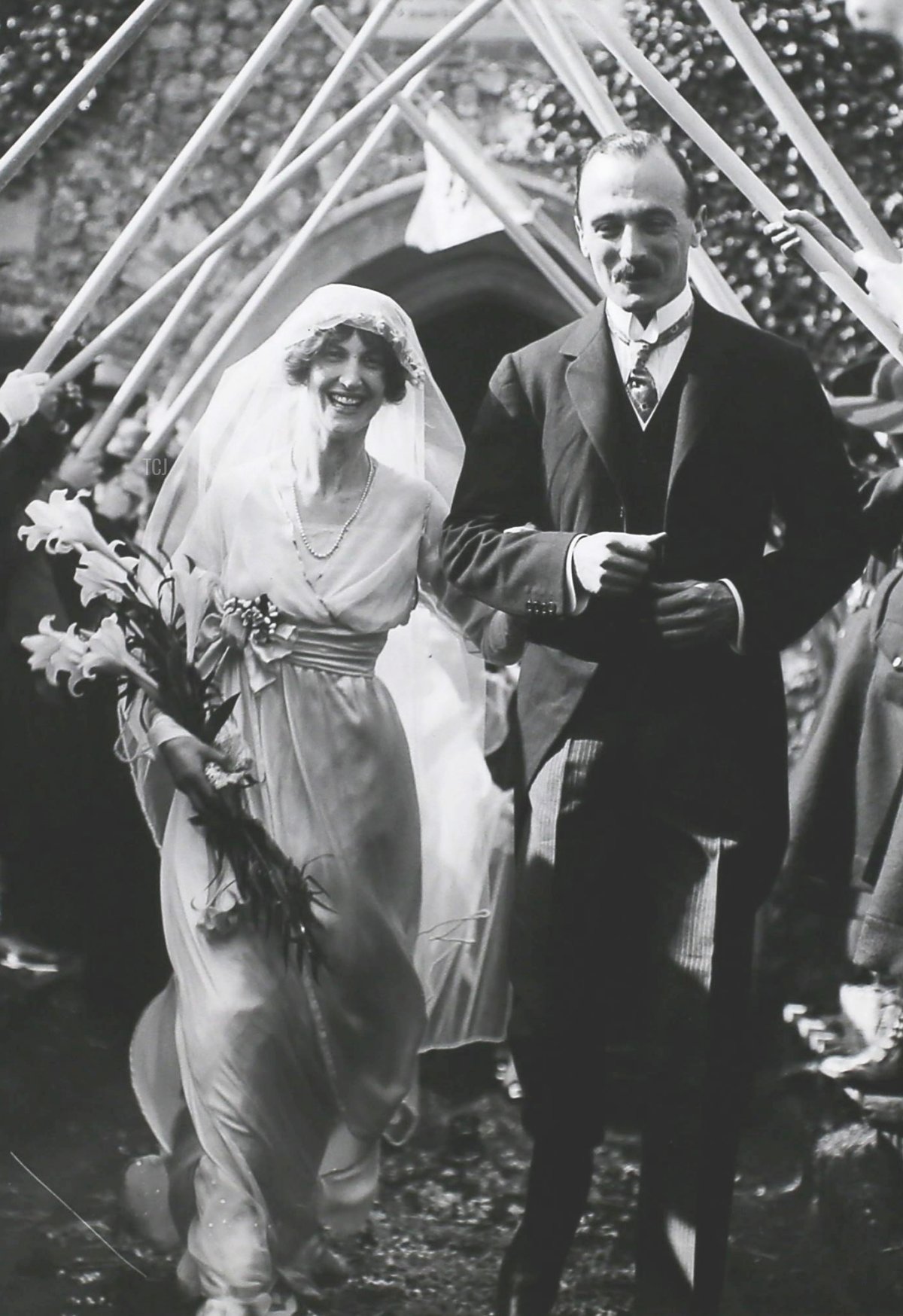 La sposa e lo sposo, Miss Phyllis Barclay e Capitano H. Cecil Johnson, escono dalla chiesa sotto un arco di bastoni delle Girl Scout dopo il loro matrimonio a Norwich, Inghilterra, 16 aprile 1914