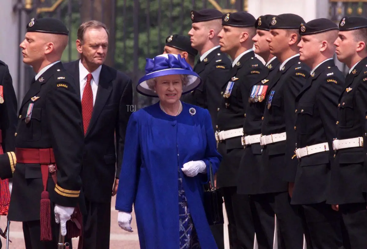 La Regina (al centro) e il Primo Ministro canadese Jean Chretien (a sinistra) ispezionano la guardia d'onore a Buckingham Palace, 13 maggio 1998.