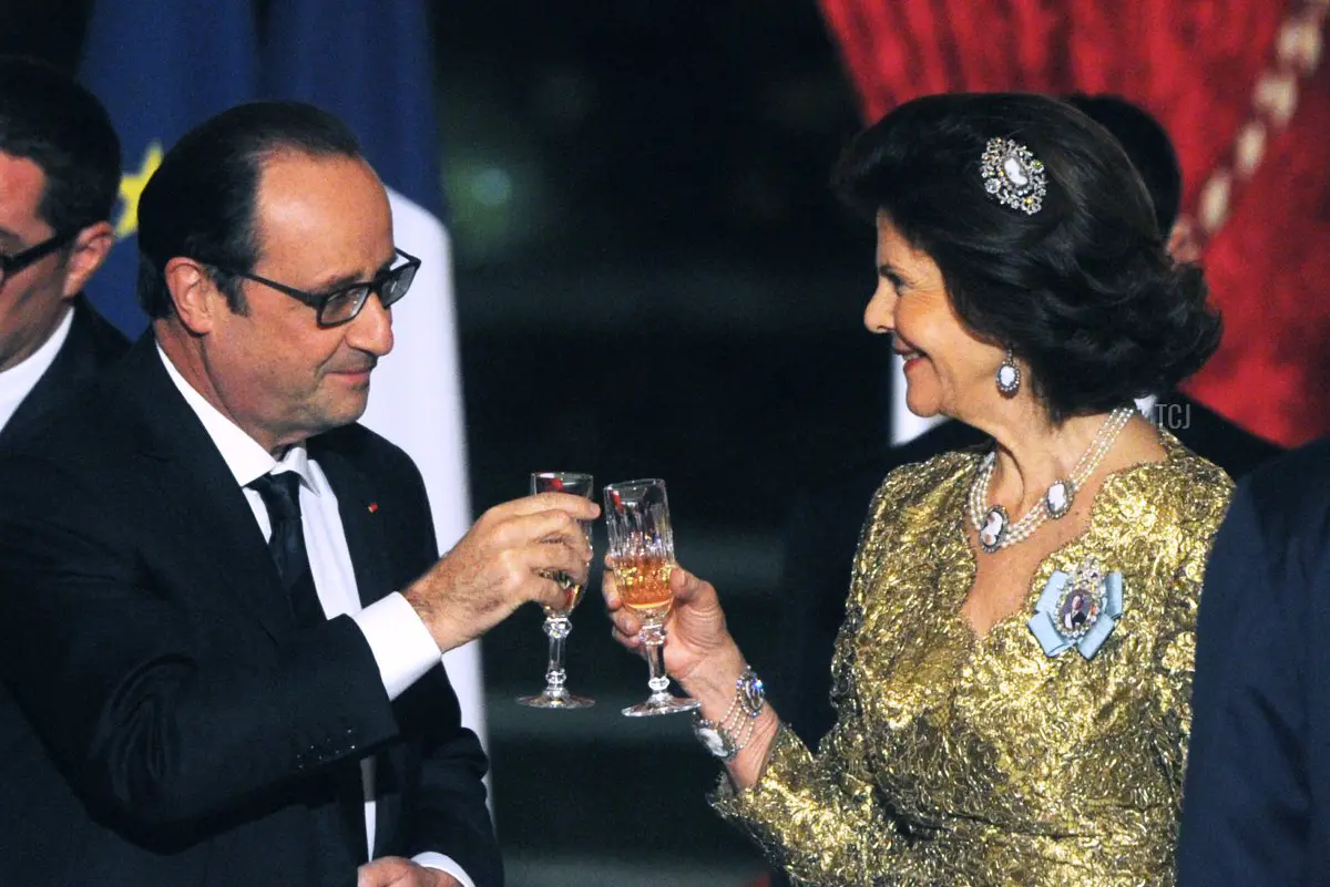 Il Presidente francese Francois Hollande (A) brinda con la Regina svedese Silvia durante una cena di Stato al palazzo presidenziale dell'Elysee a Parigi, il 2 dicembre 2014, durante la visita ufficiale della coppia svedese di tre giorni in Francia