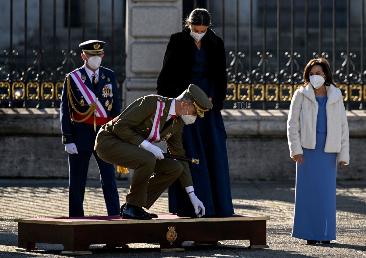 Il Re Felipe VI di Spagna (C) raccoglie un gioiello dal podio accanto alla Regina Letizia di Spagna durante la parata militare di Capodanno e le celebrazioni al Palazzo Reale di Madrid il 6 gennaio 2022