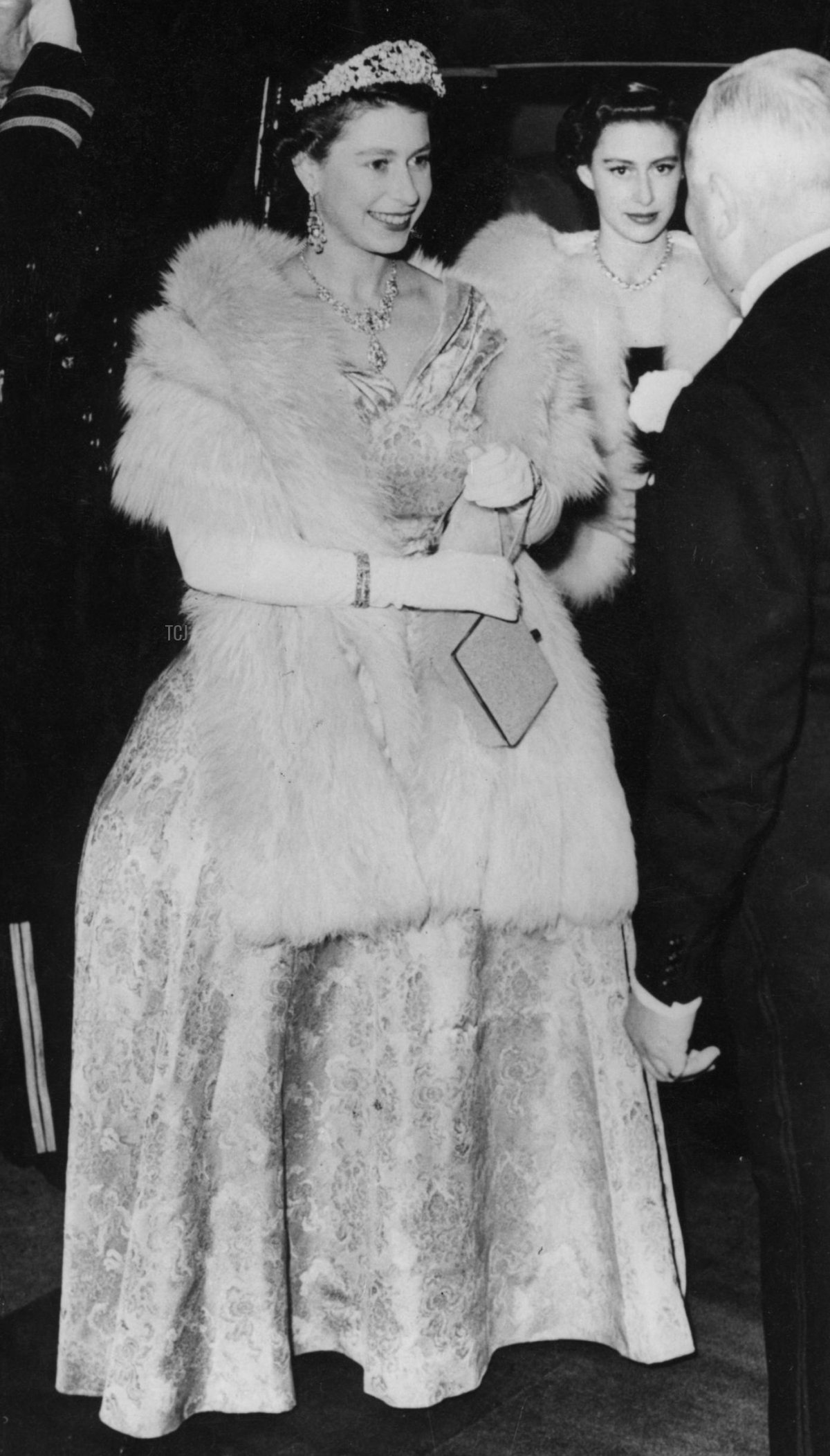 La Regina Elisabetta II sorride mentre viene ricevuta dal Principe Littler all'arrivo al London Palladium per lo Spettacolo Varietà Reale. Con lei ci sono la Principessa Margaret e il Duca di Edimburgo, 3 novembre 1952