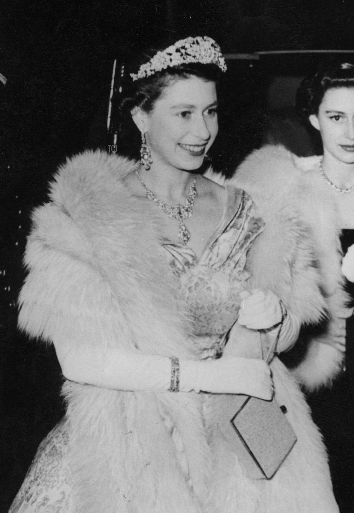 La Regina Elisabetta II sorride mentre viene ricevuta dal Principe Littler all'arrivo al London Palladium per lo Spettacolo Varietà Reale. Con lei ci sono la Principessa Margaret e il Duca di Edimburgo, 3 novembre 1952