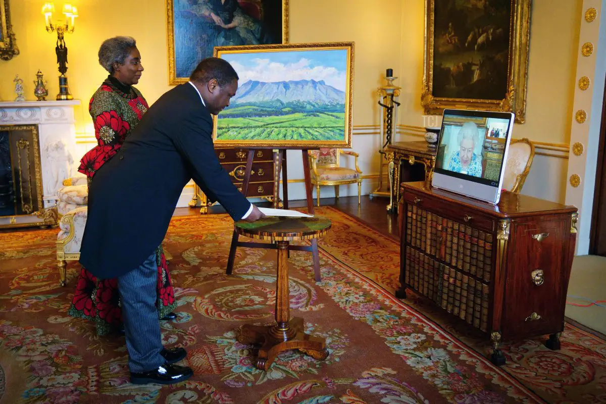 La Regina Elisabetta II appare su uno schermo tramite videolink da Windsor Castle, dove risiede, durante un'udienza virtuale per ricevere il Commissario Alto del Malawi, Dr. Thomas Bisika (al centro), e la signora Bisika (a sinistra), a Buckingham Palace il 3 marzo 2022 a Londra, Inghilterra