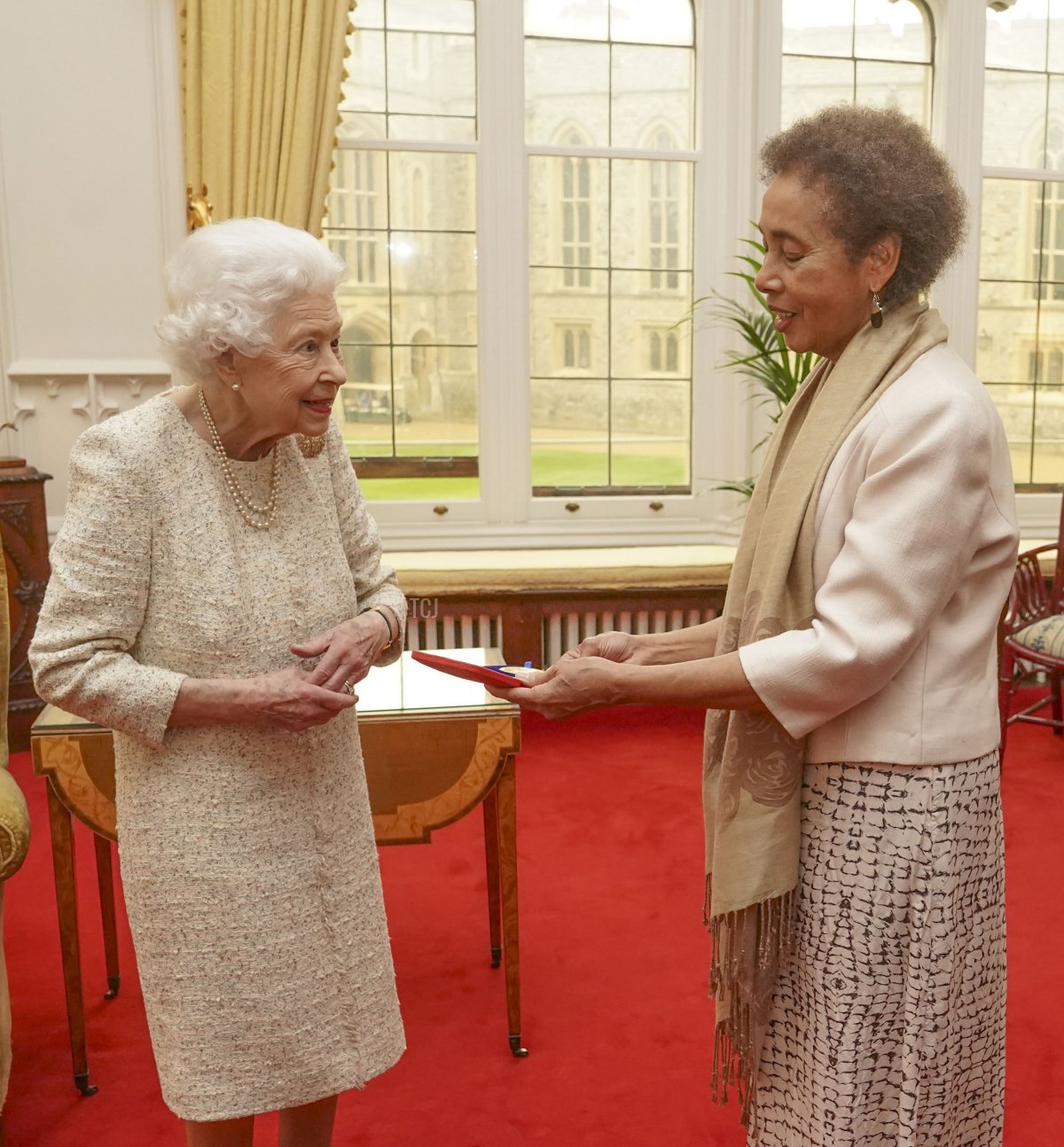 La regina britannica Elisabetta II presenta la Medaglia d'Oro della Regina per la Poesia alla poetessa guyanese Grace Nichols durante un'udienza privata al Castello di Windsor, il 16 marzo 2022