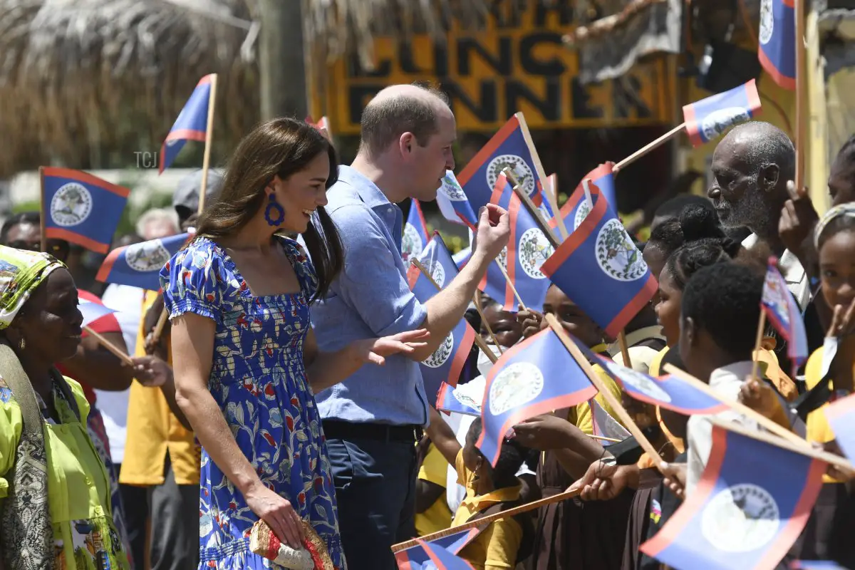 Il Principe William (C), Duca di Cambridge e la Catherine (L), Duchessa di Cambridge, salutano le persone mentre arrivano al Villaggio di Hopkins, Belize il 20 marzo 2022