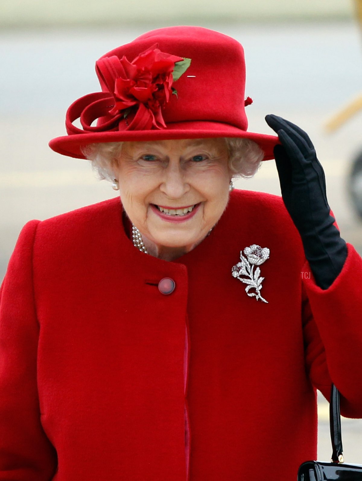 La Regina Elisabetta II tiene il cappello mentre affronta venti forti all'arrivo a RAF Valley, dove il Principe William è un pilota di elicottero di ricerca e soccorso, il 1 aprile 2011 a Holyhead, Regno Unito