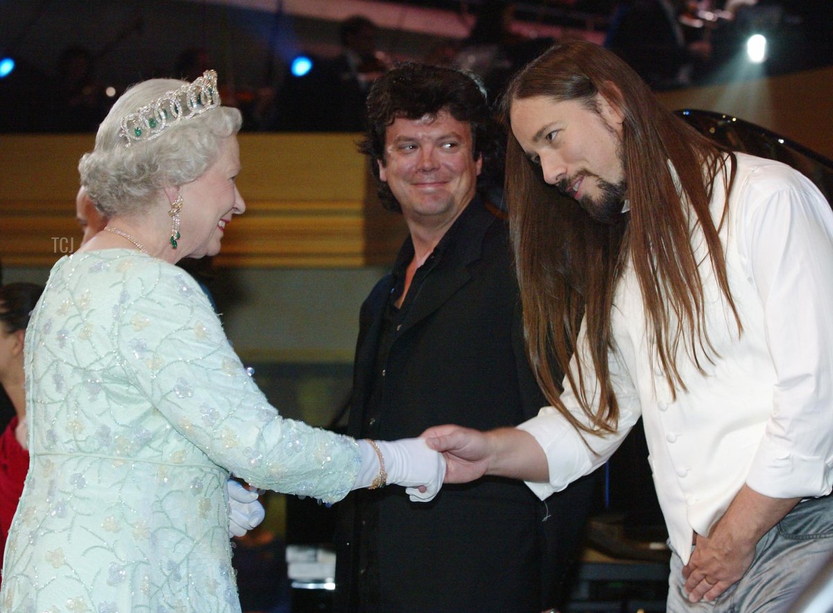 La Regina Elisabetta II incontra Robbie Baker e Paul Langlois del gruppo musicale Tragically Hip al Roy Thomson Hall dopo una performance di gala a Toronto, il 10 ottobre 2002