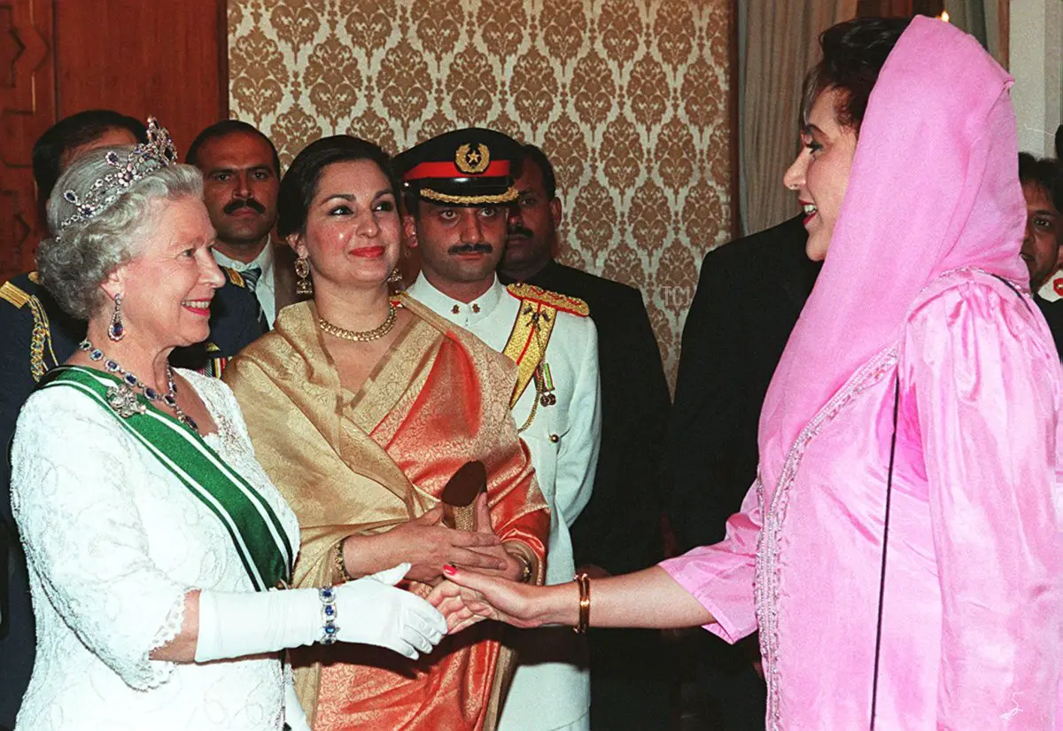 La Regina britannica in visita (L) stringe la mano al principale leader dell'opposizione pakistana Benazir Bhutto (R) durante la cena di banchetto, ospitata dal Presidente Farooq Leghari in onore della Regina, qui il 07 ottobre 1997