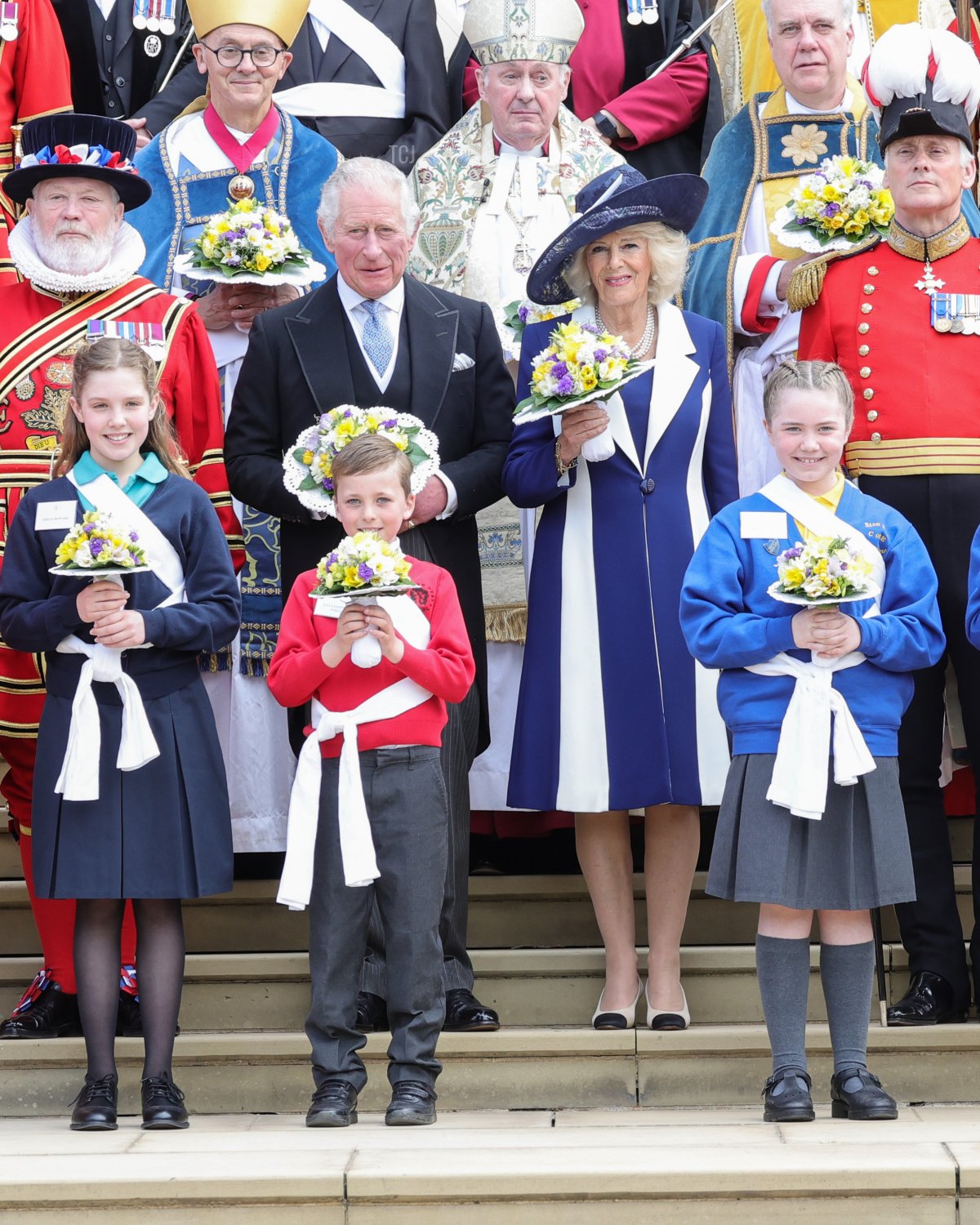 Il Principe Carlo, Principe di Galles e Camilla, Duchessa di Cornovaglia con i bouquet mentre posano con la Guardia del Corpo della Regina e gli ospiti durante il Servizio Reale di Maundy alla Cappella di San Giorgio il 14 aprile 2022 a Windsor, Inghilterra