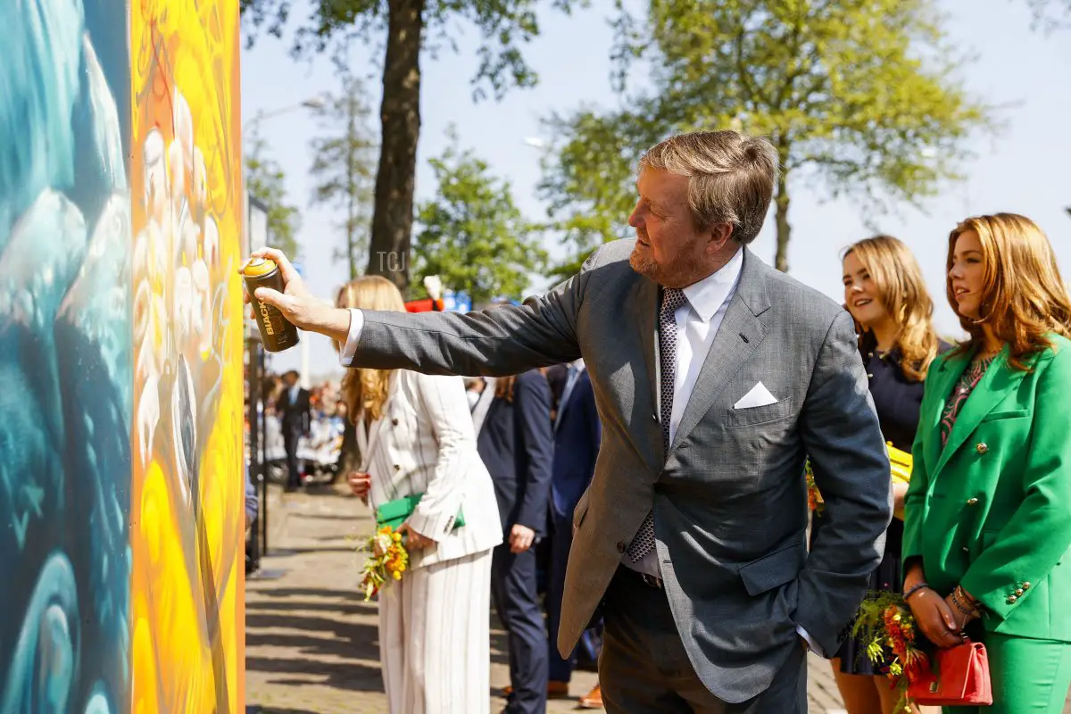 Re Guglielmo Alessandro dei Paesi Bassi (L) spruzza vernice su un murale affiancato dalla Principessa Ariane (2nd R) e dalla Principessa Alexia (R) durante un raduno per il Giorno del Re a Maastricht, il 27 aprile 2022