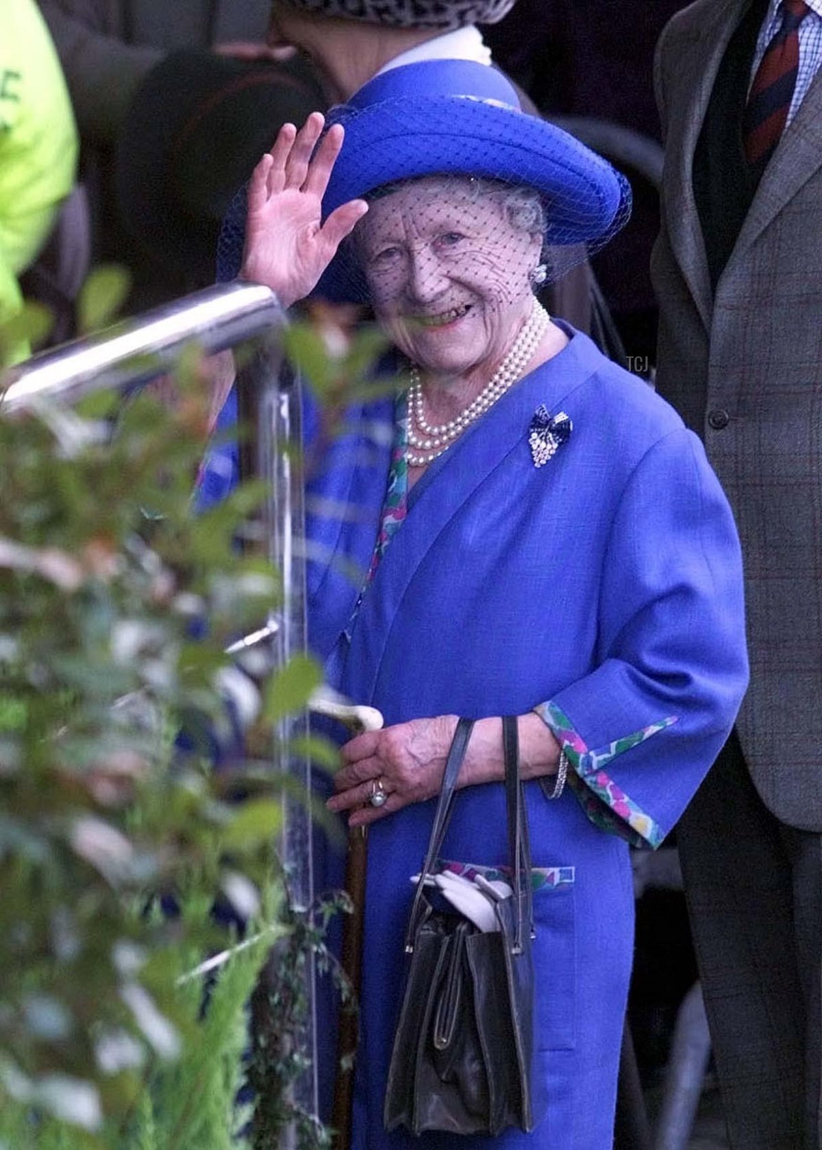 La Regina Madre saluta i benemeriti mentre arriva per il terzo e ultimo giorno del festival di Cheltenham, 18 marzo 1999