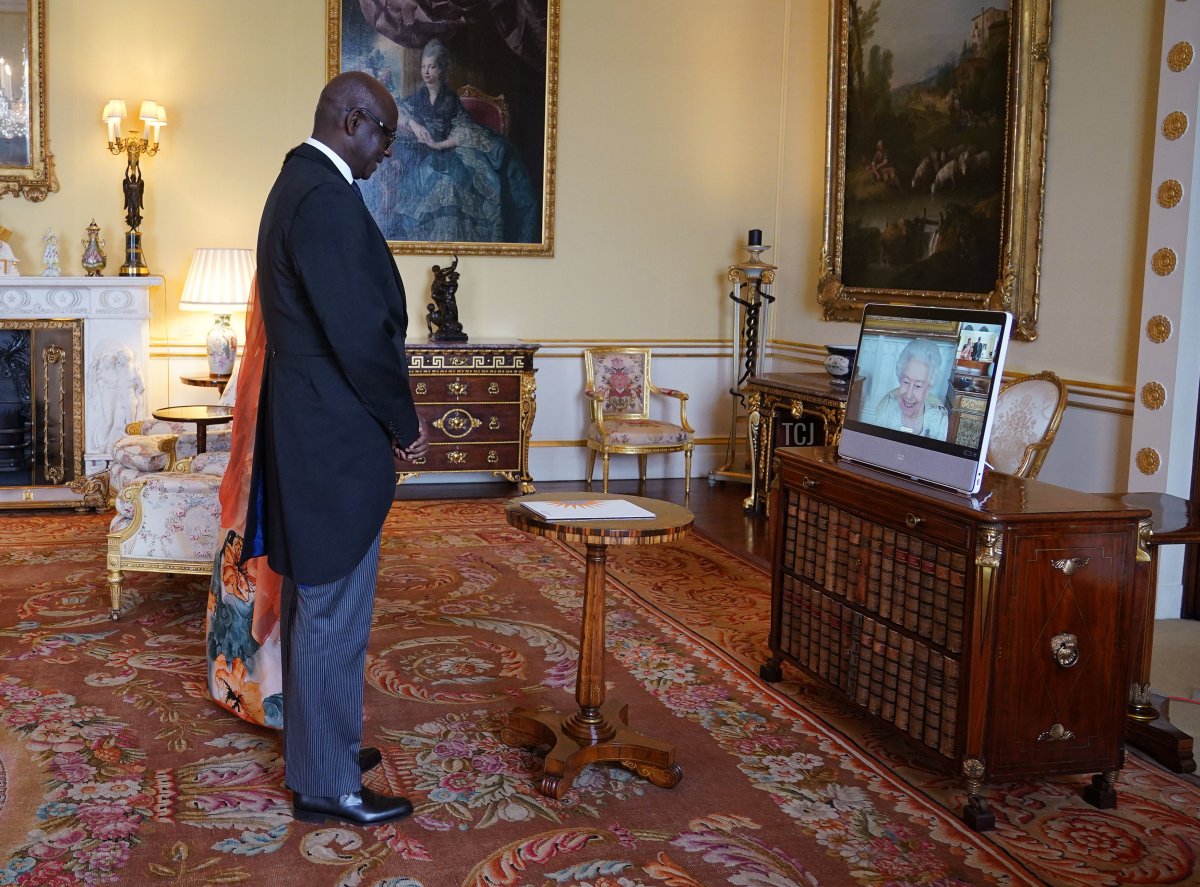 La regina Elisabetta II, residente al Castello di Windsor, appare su uno schermo tramite videolink, durante un'udienza virtuale per ricevere Johnston Busingye, alto commissario per la Repubblica del Rwanda, e sua moglie Phoebe Murerwa, a Buckingham Palace il 29 aprile 2022 a Londra, in Inghilterra