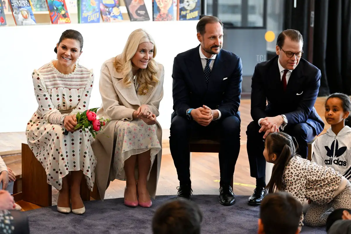 La Principessa Vittoria di Svezia (sinistra), il Principe Daniel di Svezia (destra), la Principessa Mette-Marit di Norvegia (seconda a sinistra) e il Principe Haakon di Norvegia (secondo a destra) parlano con i bambini riguardo ai libri durante una visita al Kulturhuset di Stoccolma, Svezia, il 2 maggio 2022