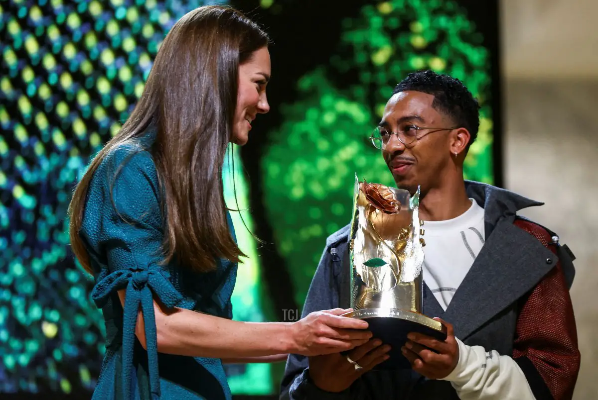 Britain's Catherine, Duchess of Cambridge (L) gives the trophy of 