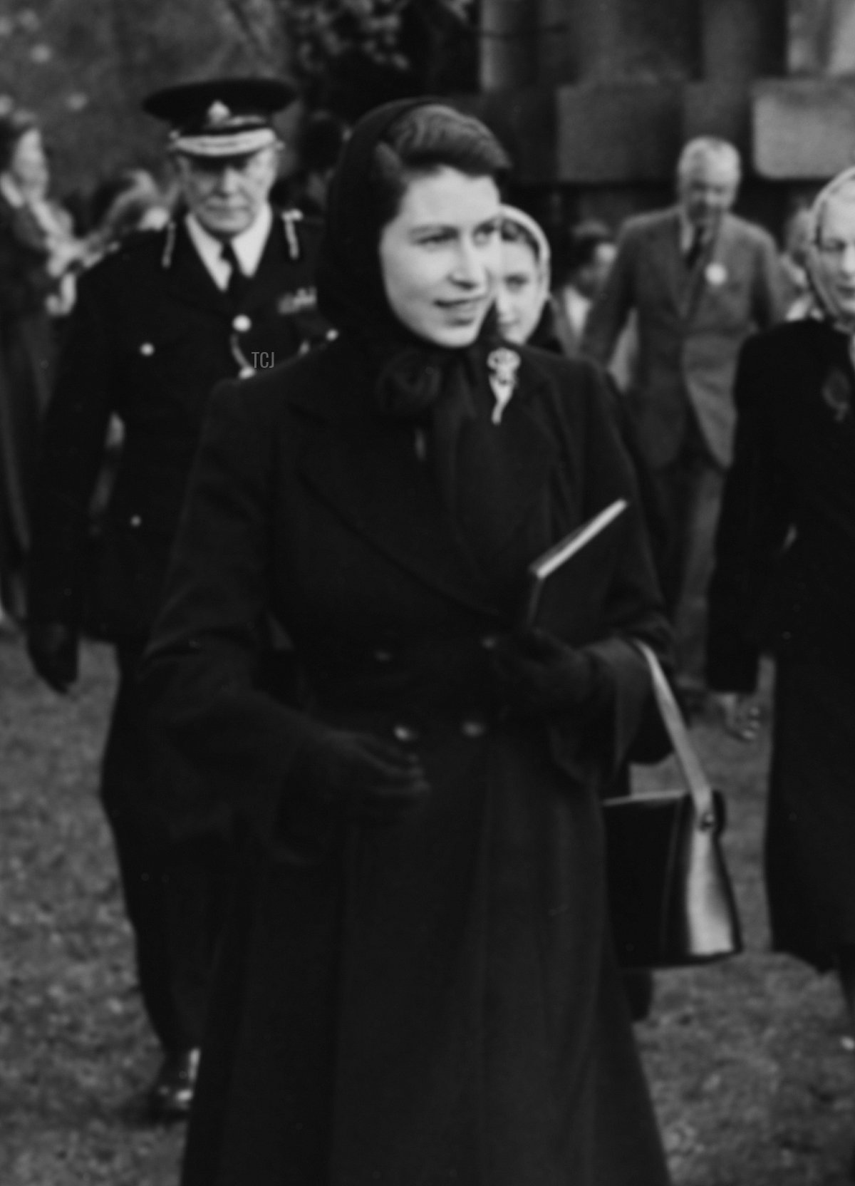 La Regina Elisabetta II e il Duca di Beaufort passano davanti a una folla di persone mentre si dirigono per assistere alle prove olimpiche equestre a Badminton, Inghilterra, 23 aprile 1952