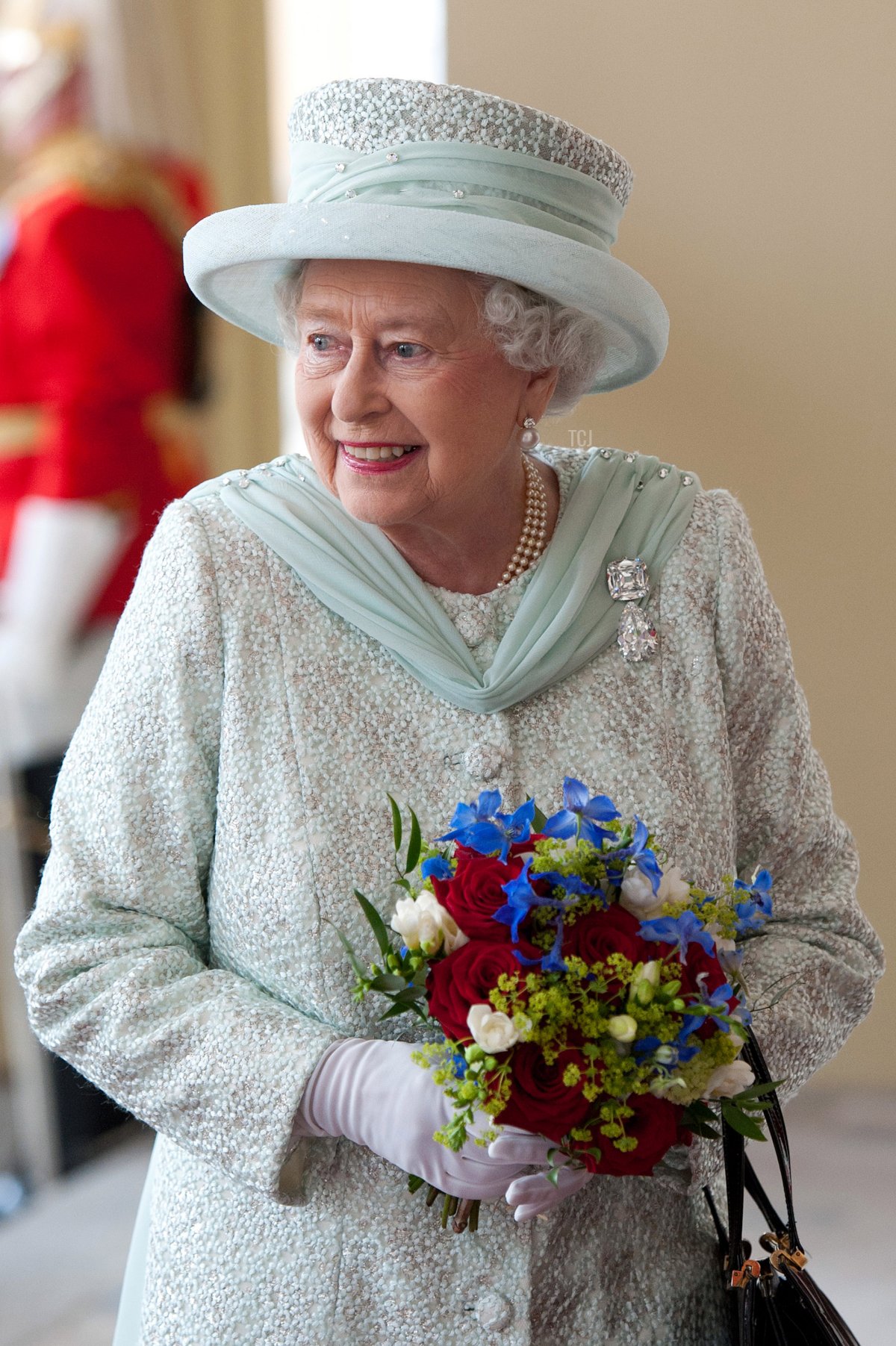 Queen Elizabeth II holds a bouquet of flowers as she arrives at Buckingham Palace at the end of a carriage procession following a national service of thanksgiving in honour of the Queen's Diamond Jubilee on June 5, 2012 in London, England