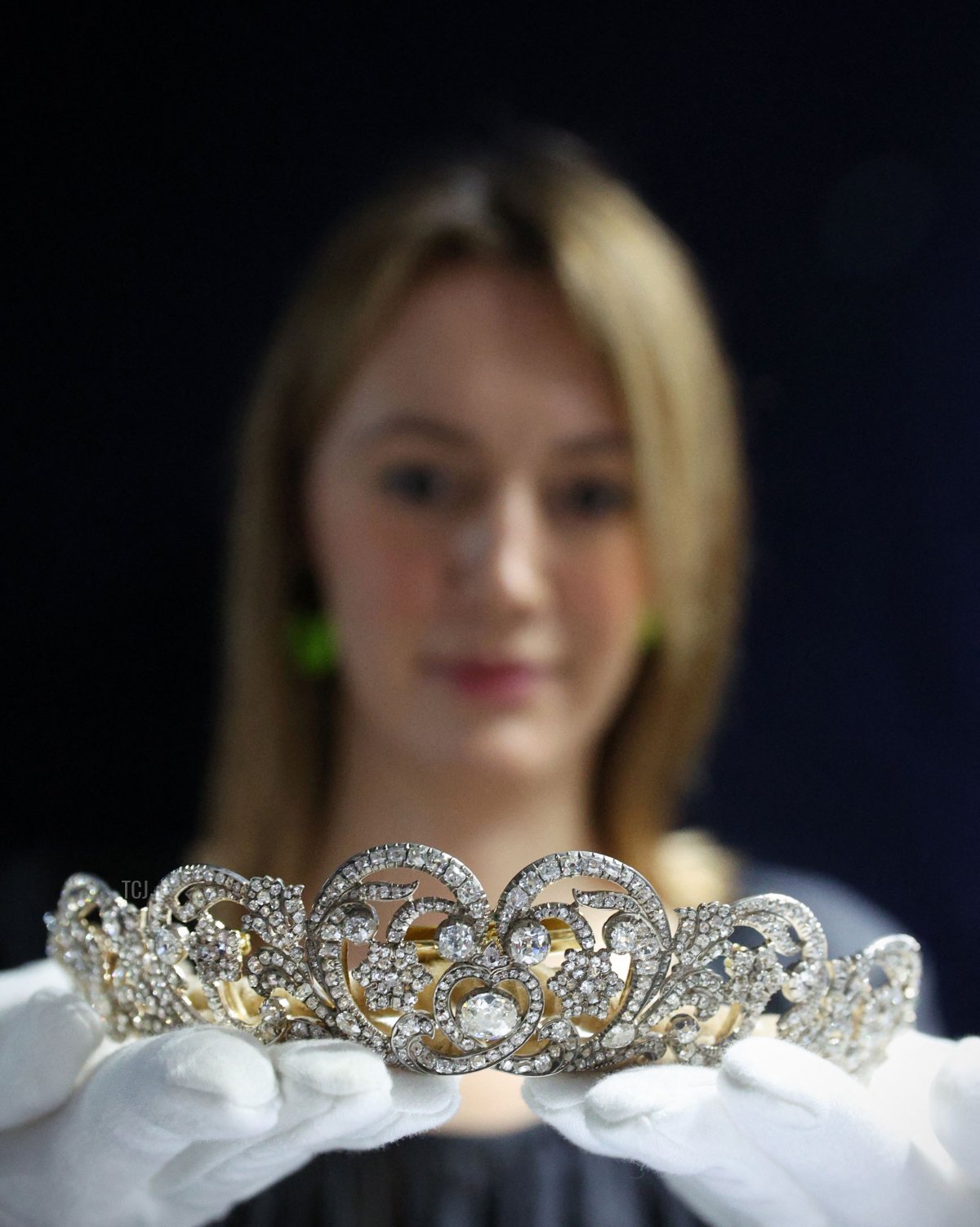 Un dipendente di Sotheby's solleva la 'Tiara Spencer', indossata dalla Principessa Diana nel giorno delle sue nozze nel 1981, durante una photocall per promuovere la Stagione del Giubileo di Sotheby's a Londra il 27 maggio 2022