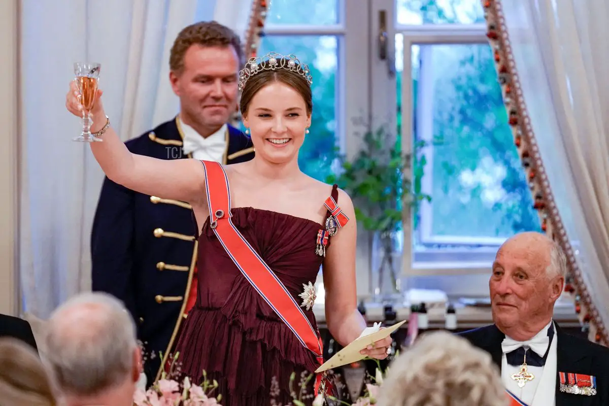 Norway's Princess Ingrid Alexandra (L) raises her glass for a toast next to Norway's King Harald V, as she delivers a speech during a gala dinner for her 18th birthday in Oslo on June 17, 2022