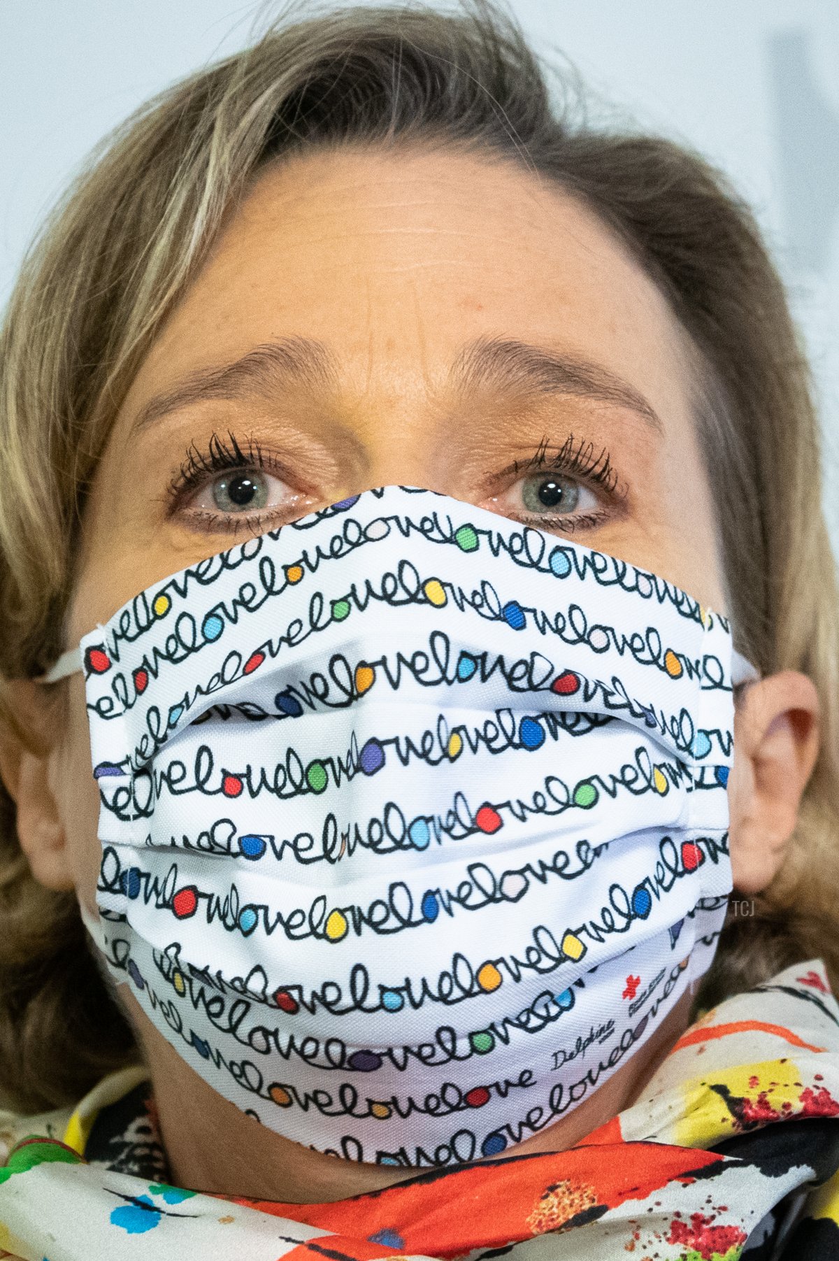 La Principessa Delphine durante una conferenza stampa indossando una mascherina decorata.