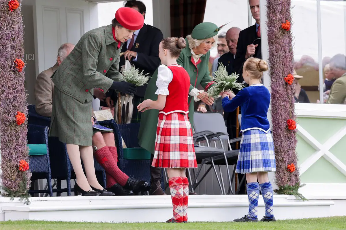 Anne, Princess Royal and Camilla, Duchess of Cornwall present heather posies to Chloe Guy and Cassie Stewart during the Braemar Highland Gathering at the Princess Royal & Duke of Fife Memorial Park on September 03, 2022 in Braemar, Scotland