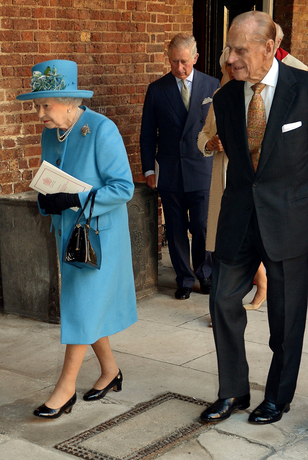 La Regina Elisabetta II e il Duca di Edimburgo davanti al Principe di Galles (sullo sfondo) lasciano la Cappella Reale nel Palazzo di St James a Londra il 23 ottobre 2013, dopo il battesimo del Principe Giorgio di Cambridge