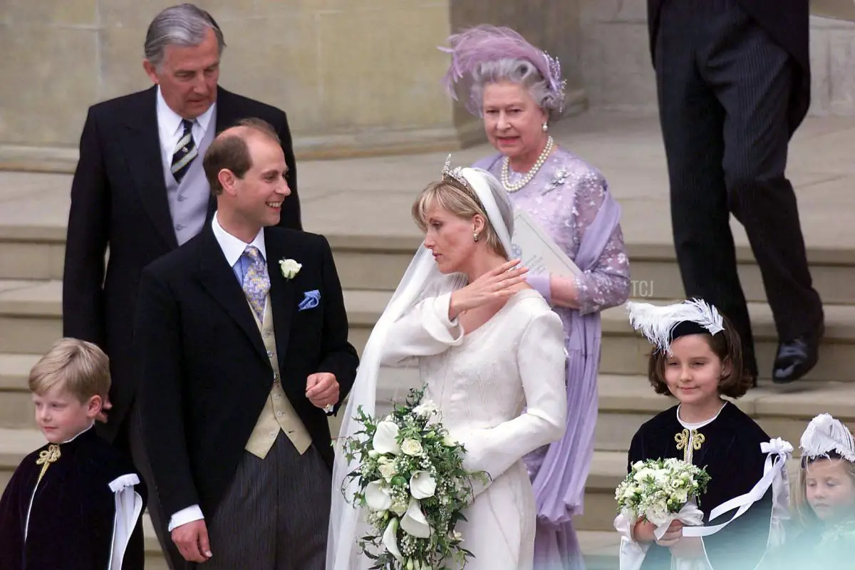 Il Principe Edoardo d'Inghilterra e sua moglie Sophie Rhys-Jones (davanti C) all'esterno della Cappella di San Giorgio a Windsor con il padre Christopher Rhys-Jones (dietro L) e la Regina Elisabetta II (C, dietro) dopo il loro matrimonio 19 Giugno 1999