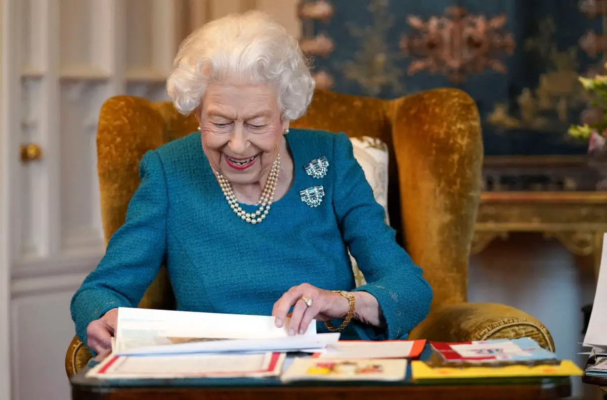 Una foto rilasciata a Londra il 4 febbraio 2022, scattata il mese precedente, mostra la Regina Elisabetta II mentre osserva una mostra di memorabilia dei suoi Giubilei d'Oro e Platino, nella Oak Room di Windsor Castle, a ovest di Londra