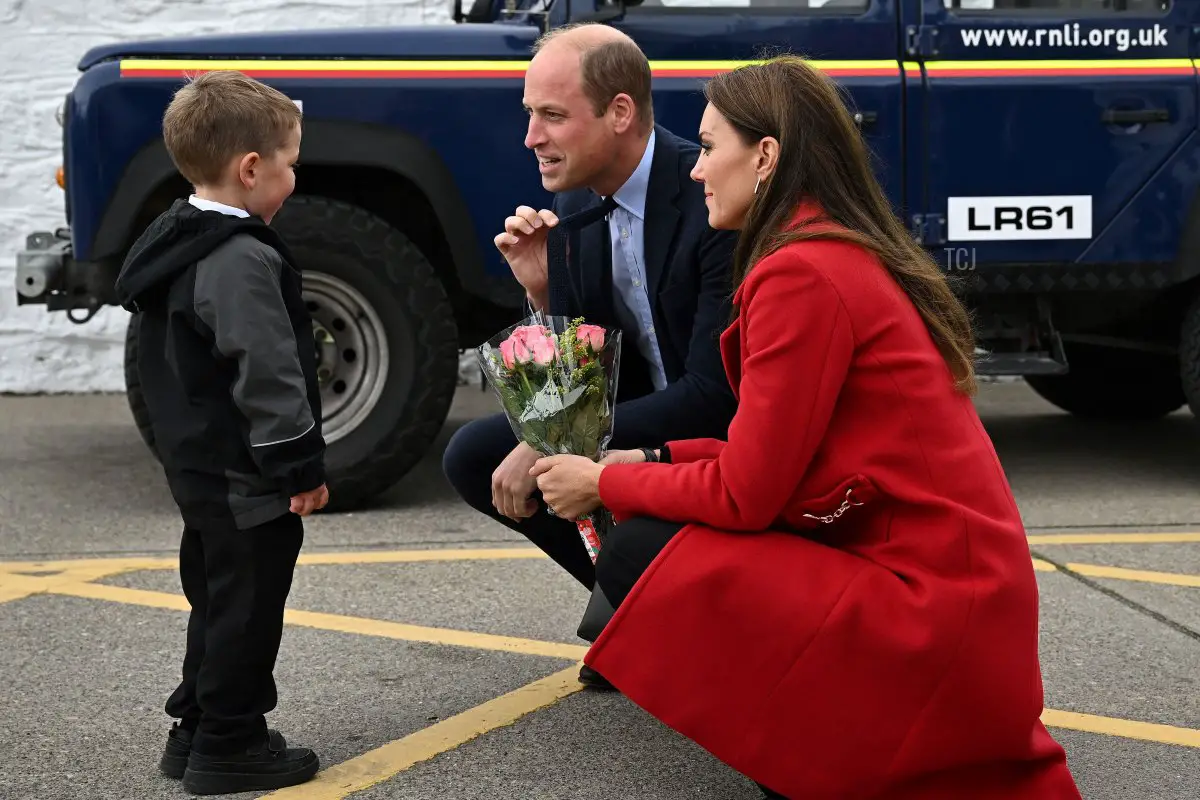 William, Principe di Galles, gesticola mentre la moglie Catherine riceve un mazzo di fiori da Theo, un bimbo di quattro anni, durante la visita alla stazione di salvataggio RNLI.