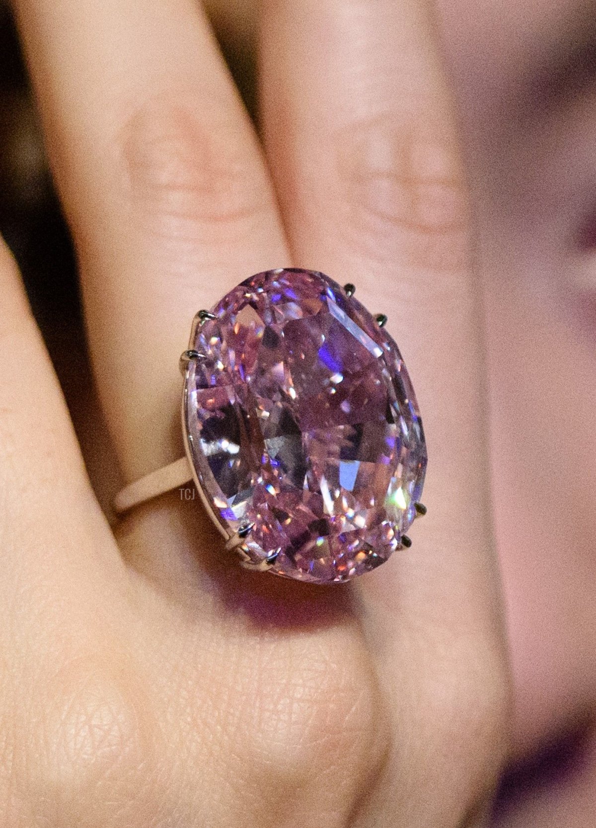 Un modello posa con un diamante rosa ovale misto da 59.60 carati, noto come 'The Pink Star', durante una presentazione stampa di Sotheby's a Hong Kong il 29 marzo 2017, per promuovere la sua asta del 4 aprile