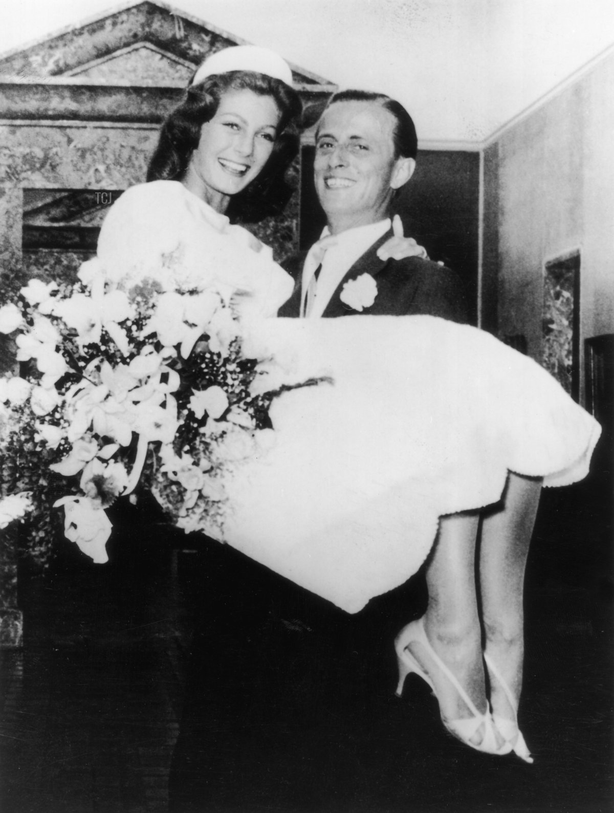 Baron Hans Heinrich von Thyssen-Bornemisza (1912 - 2002) carries his new bride, British fashion model Fiona Campbell-Walter, over the threshold of his villa at Lugano, after their wedding at Castagnola