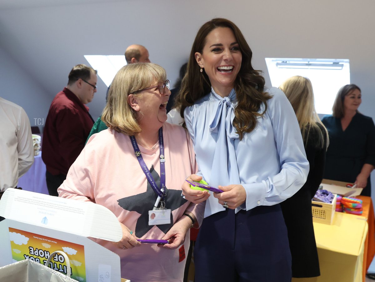 Catherine, Principessa di Galles ride con un volontario durante una visita a PIPS Suicide Prevention (PIPS Charity) a Belfast che lavora in diverse comunità della città e in tutta l'Irlanda del Nord per fornire supporto alle persone a rischio di suicidio e autolesionismo, come parte della visita reale in Irlanda del Nord il 6 ottobre 2022 a Belfast, Irlanda del Nord