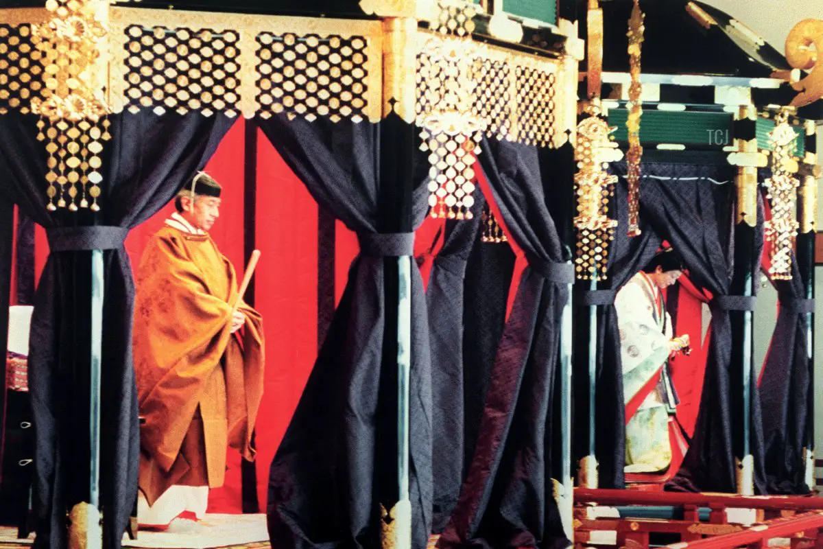 L'Imperatore Akihito (a sinistra), indossando un costume tradizionale giapponese, si trova all'interno del Takamikura (trono imperiale) durante la cerimonia di incoronazione al Palazzo Imperiale, 12 novembre 1990. A destra c'è l'Imperatrice Michiko