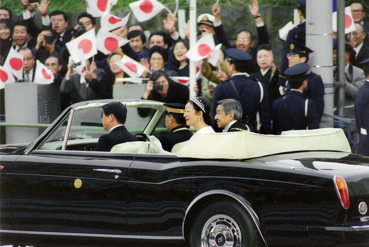 Un neocoronata Imperatore giapponese Akihito e moglie Imperatrice Michiko procedono attraverso il centro di Tokyo in un corteo, salutando i ben auguranti, il 12 novembre 1990