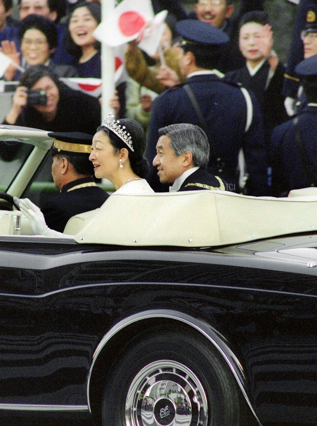 Un neocoronata Imperatore giapponese Akihito e moglie Imperatrice Michiko procedono attraverso il centro di Tokyo in un corteo, salutando i ben auguranti, il 12 novembre 1990