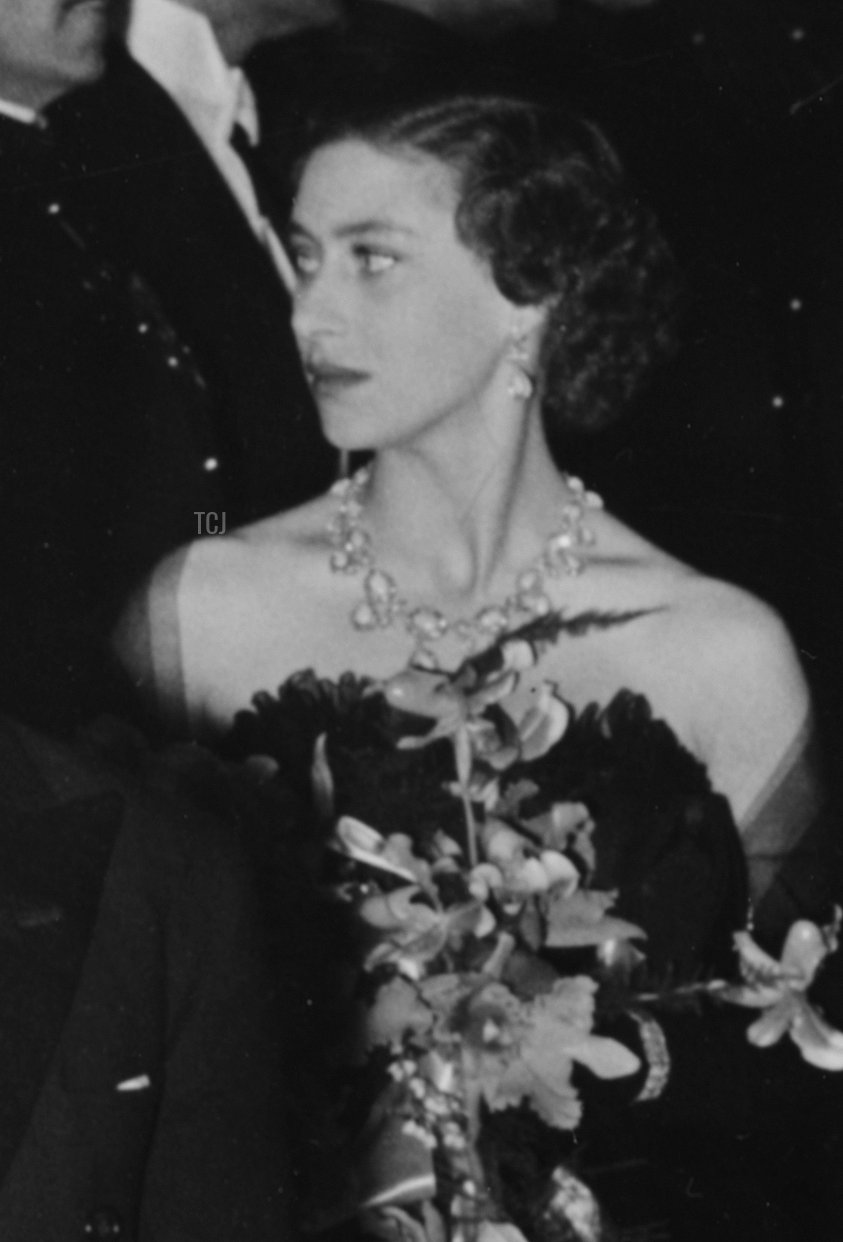 La regina Elisabetta II è scortata da Reginald Bromhead, presidente del Cinematograph and Trade Benevolent Fund, mentre lei e la principessa Margaret (dietro) lasciano la proiezione del film a Leicester Square, Londra, 27 ottobre 1952