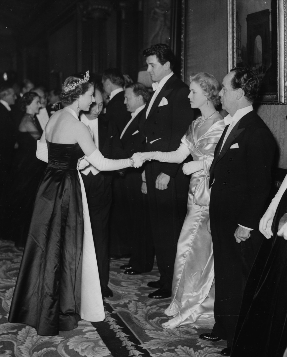 L'attrice Veronica Hurst, con l'attore Rock Hudson alla sua destra, è presentata alla regina Elisabetta II durante la proiezione reale a Leicester Square, Londra, 27 ottobre 1952