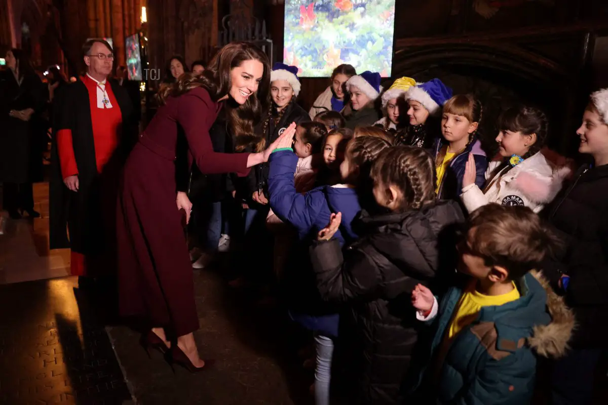 Britain's Catherine, Princess of Wales speaks to children as she arrives to attend the 'Together at Christmas Carol Service' at Westminster Abbey, in London, on December 15, 2022