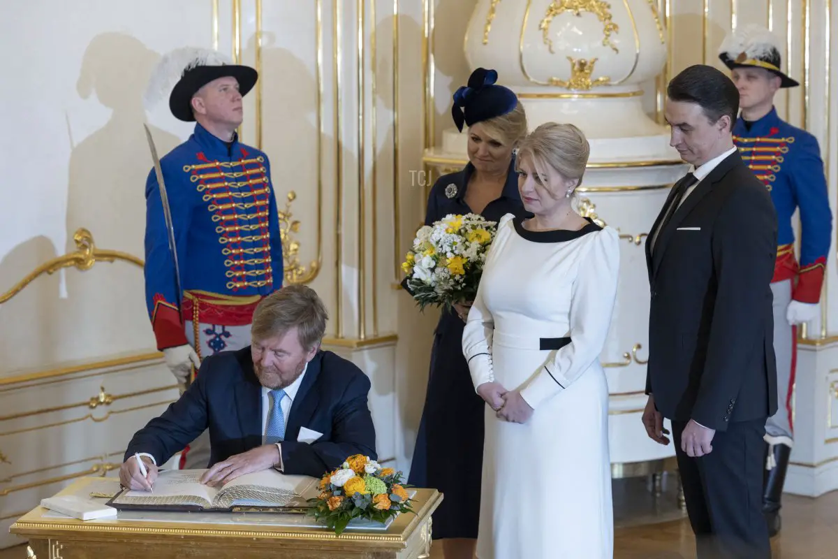 Il Re Willem-Alexander dei Paesi Bassi firma un registro degli ospiti mentre la Regina Massima dei Paesi Bassi, la Presidente Zuzana Caputova della Slovacchia e il suo compagno, Juraj Rizman, osservano durante una cerimonia di benvenuto al Palazzo Presidenziale a Bratislava il 7 marzo 2023 (TOMAS BENEDIKOVIC/AFP via Getty Images)