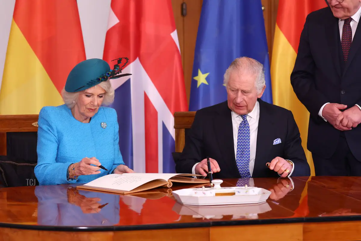 La regina Camilla firma il libro degli ospiti ufficiali mentre il re Carlo III osserva a Schloss Bellevue durante il primo giorno della loro visita di stato in Germania il 29 marzo 2023 a Berlino, Germania (Sebastian Reuter/Getty Images)