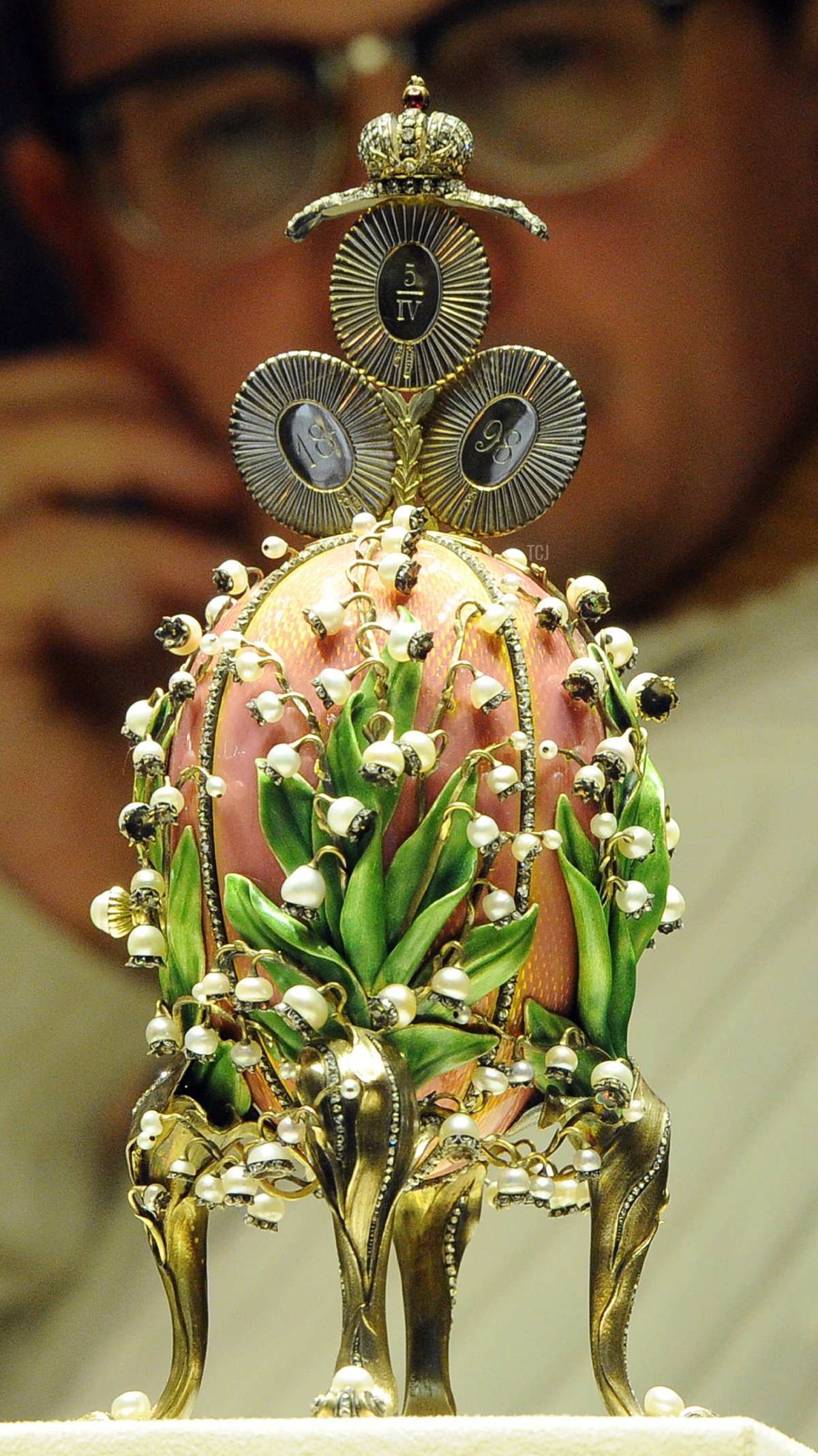 Un uomo osserva l'uovo dei mughetti, creato da Peter Carl Faberge, al Museo Fabergé di San Pietroburgo il 19 novembre 2013 (OLGA MALTSEVA/AFP via Getty Images)