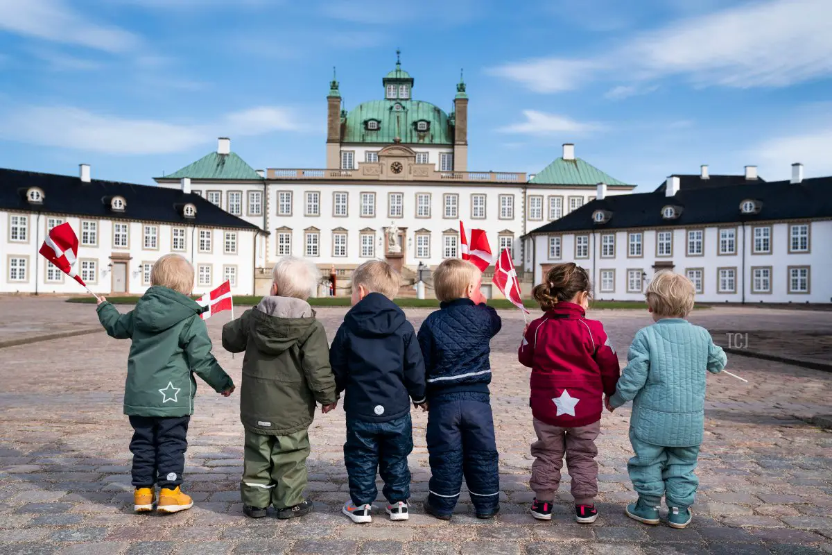 Bambini salutano con bandiere danesi nel Palazzo di Fredensborg, Danimarca, il 16 aprile 2021, per l'81° compleanno della Regina Margrethe II di Danimarca, che celebrava in privato a causa della pandemia da coronavirus (MARTIN SYLVEST/Ritzau Scanpix/AFP via Getty Images)