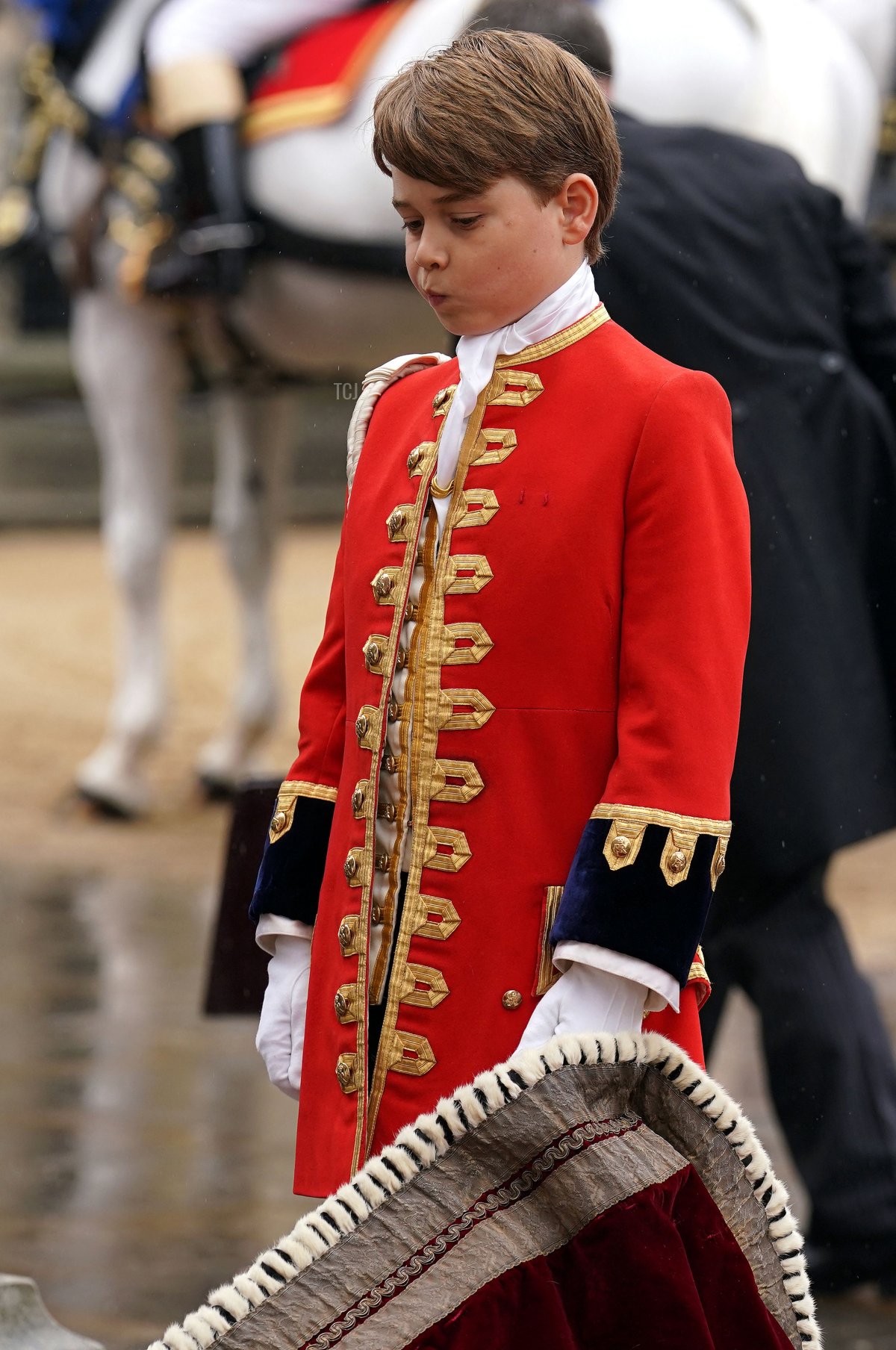 Il Principe Giorgio di Galles tiene il mantello di suo nonno, il Re Carlo III, all'Abbazia di Westminster, nel centro di Londra il 6 maggio 2023, durante l'incoronazione (ANDREW MILLIGAN/POOL/AFP via Getty Images)