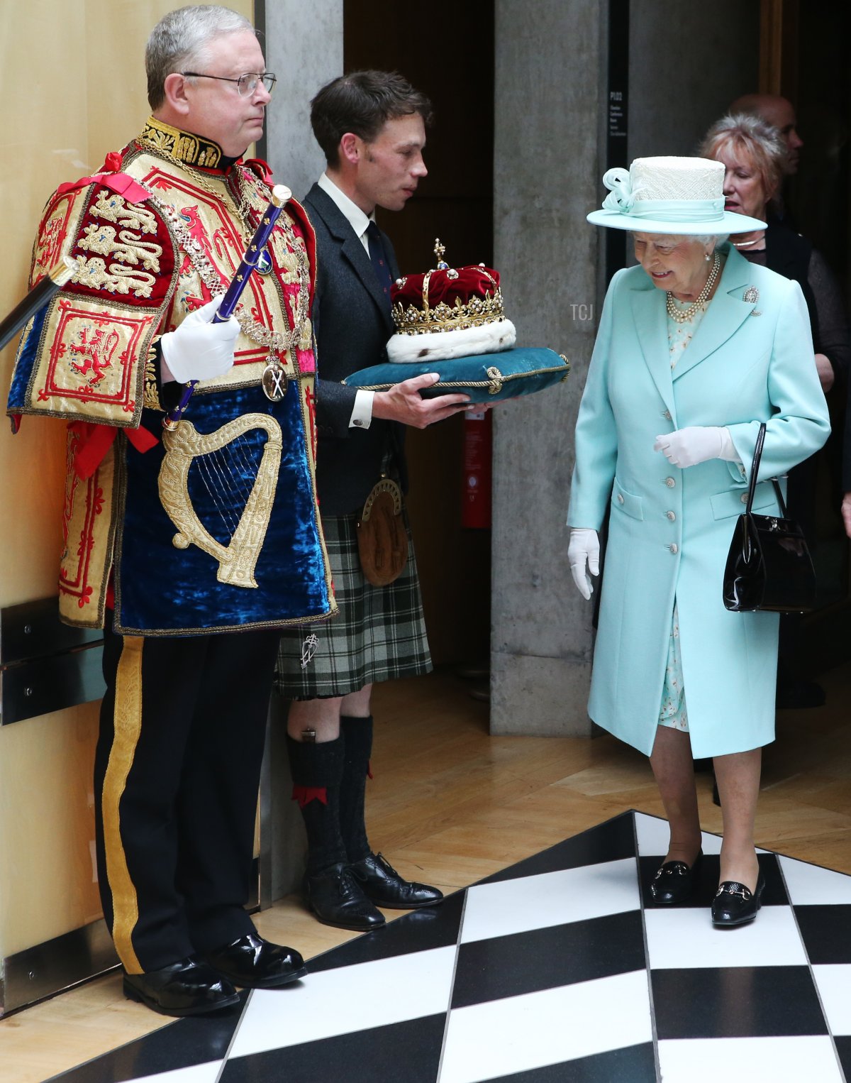 La regina Elisabetta II esamina la Corona di Scozia, tenuta dal Duca di Hamilton, mentre passeggiano attraverso il Corridoio Bianco e Nero, dopo l'apertura della quinta sessione del Parlamento scozzese il 2 luglio 2016 a Edimburgo, Regno Unito (Andrew Milligan/WPA Pool/Getty Images)