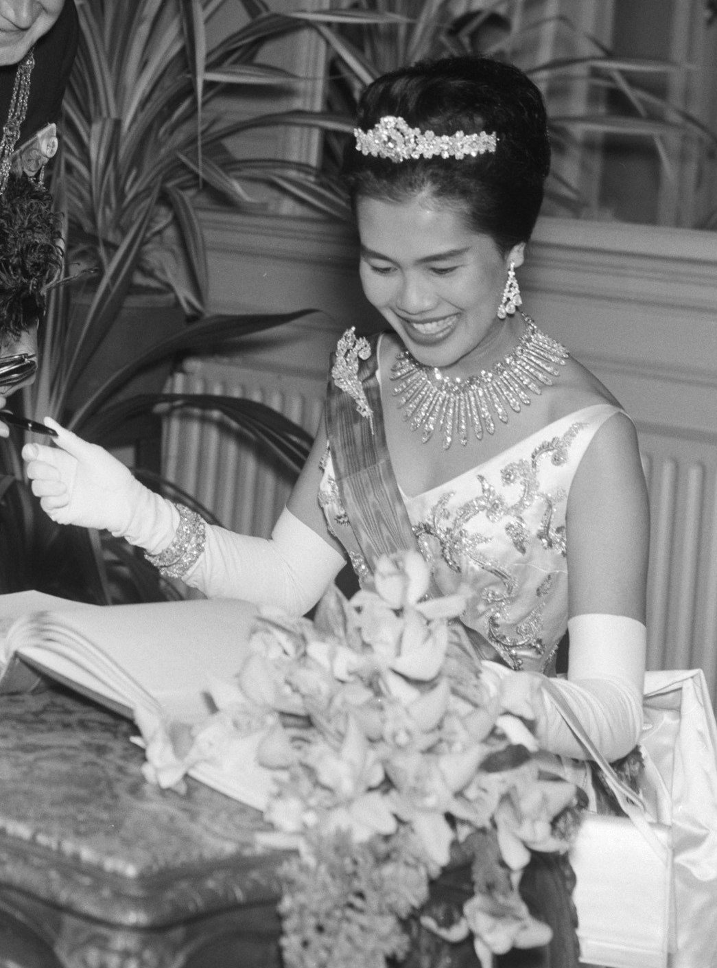 La regina Sirikit di Thailandia firma un libro degli ospiti prima di un concerto di gala all'Aia il 25 ottobre 1960 (Joop van Bilsen/Anefo/Nationaal Archief/Wikimedia Commons)